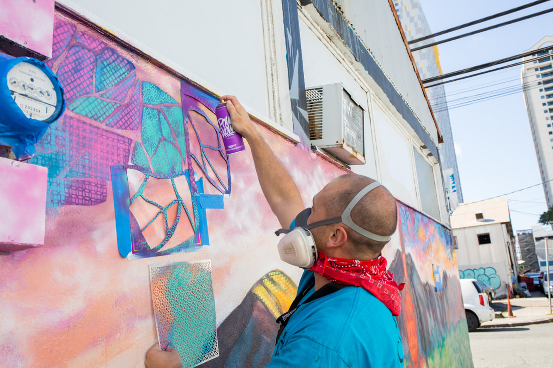 Adam spray-painting a mural